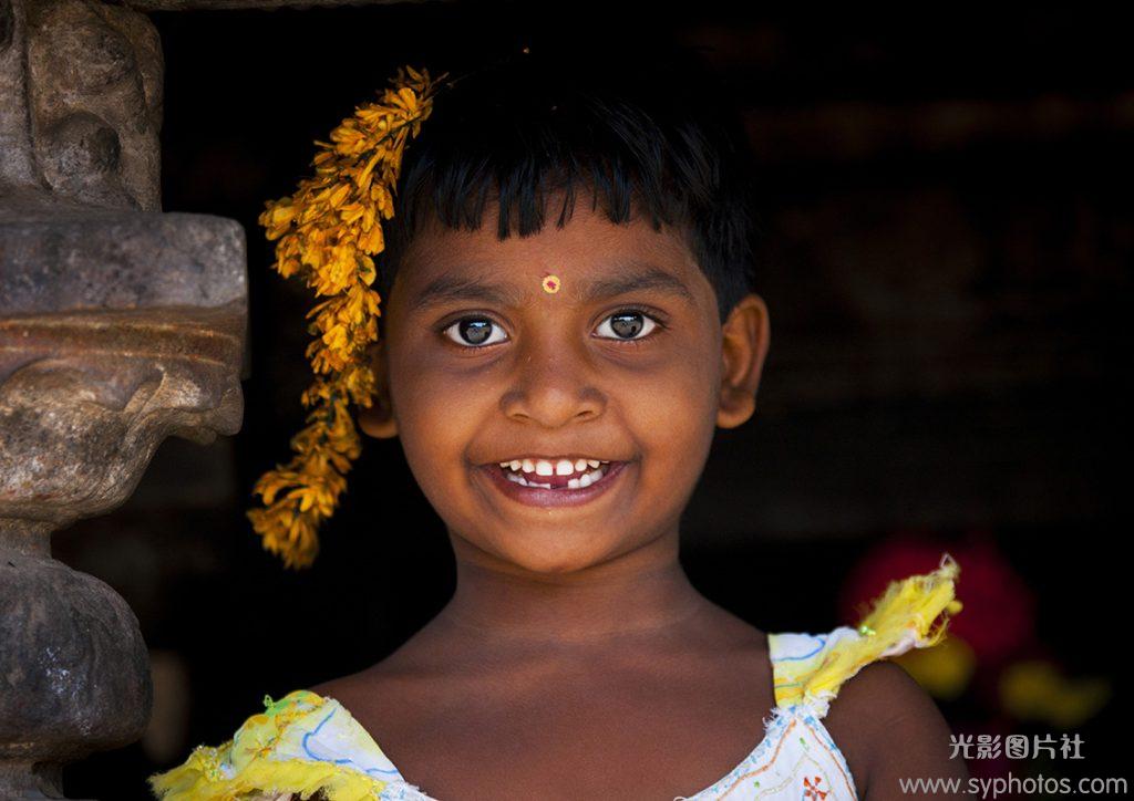 Portait Of A Smiling Gap-toothed Young Girl With Flowers In Her Hairs, Kumbakonam, India